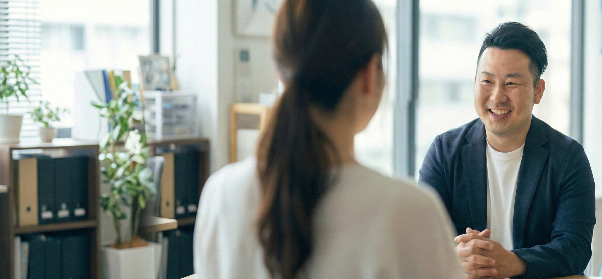 相談者と向き合い、笑顔で話す田中康志